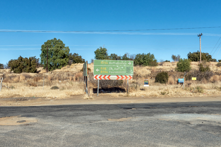 KOFFIEFONTEIN, SOUTH AFRICA, AUGUST 6, 2018: A directional sign near Koffiefontein in the Free State Province. Electricity infrastructure is visibleのeditorial素材