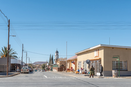 PETRUSVILLE, SOUTH AFRICA, AUGUST 6, 2018: A street scene with businesses, people  and vehicles, in Petrusville in the Northern Cape Province. The Dutch Reformed Church is visibleのeditorial素材