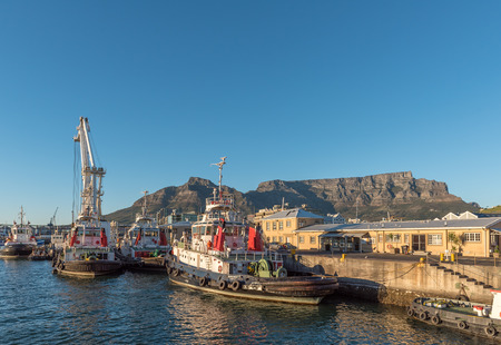 CAPE TOWN, SOUTH AFRICA, AUGUST 9, 2018: Tugboats at the harbor in Cape Town in the Western Cape Province. Table Mountain is visible in the backのeditorial素材