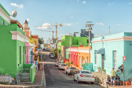 CAPE TOWN, SOUTH AFRICA, AUGUST 17, 2018: A street scene, with multi-colored houses, in the Bo-Kaap in Cape Town in the Western Cape Province. A Masjid, people, vehicles and construction cranes are visibleのeditorial素材