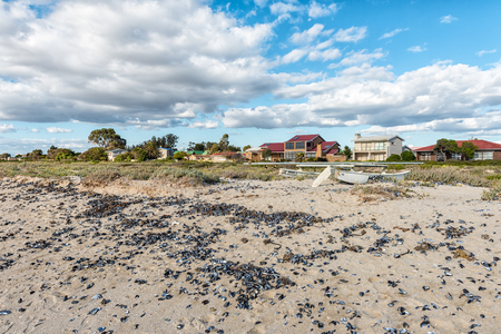 DWARSKERSBOS, SOUTH AFRICA, AUGUST 21, 2018: A beach scene in Dwarskersbos in the Western Cape Province. Houses, a catamaran and seashells are visibleのeditorial素材