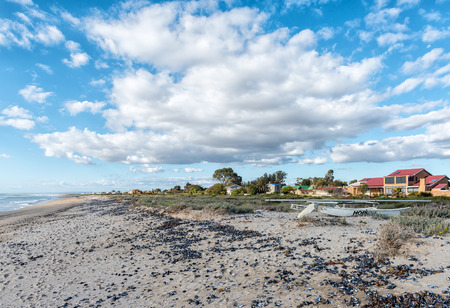 DWARSKERSBOS, SOUTH AFRICA, AUGUST 21, 2018: A beach scene in Dwarskersbos in the Western Cape Province. Houses, a catamaran and seashells are visibleのeditorial素材