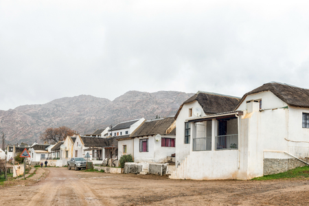 WUPPERTHAL, SOUTH AFRICA, AUGUST 27, 2018: A street scene, with historic houses, people and vehicles, in Wupperthal in the Cederberg Mountains of the Western Cape Provinceのeditorial素材