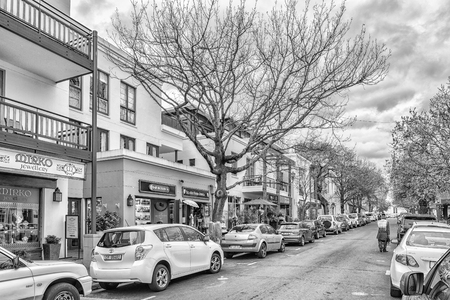 STELLENBOSCH, SOUTH AFRICA, AUGUST 16, 2018: Church Street with the historic Dutch Reformed Mother Church visible. Vehicles, businesses and people are visible. Monochromeのeditorial素材