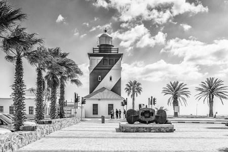 CAPE TOWN, SOUTH AFRICA, AUGUST 17, 2018: The Green Point Lighthouse at Mouille Point in Cape Town in the Western Cape Province. An historic ships anchor and people are visible. Monochromeのeditorial素材