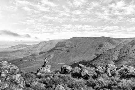 TANKWA KAROO NATIONAL PARK, SOUTH AFRICA, AUGUST 31, 2018: A tourist at the viewpoint in the Gannaga Pass in the Tankwa Karoo of South Africa. Monochromeのeditorial素材