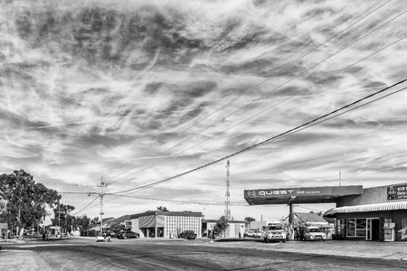 CARNAVON, SOUTH AFRICA, AUGUST 31, 2018: A street scene, with vehicles, people and businesses, in Carnavon in the Northern Cape Province. Monochromeのeditorial素材