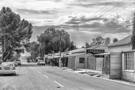 LUCKHOFF, SOUTH AFRICA, SEPTEMBER 1, 2018:  A street scene, with businesses, vehicles and people, in Luckhoff in the Northern Cape Province. Monochromeのeditorial素材