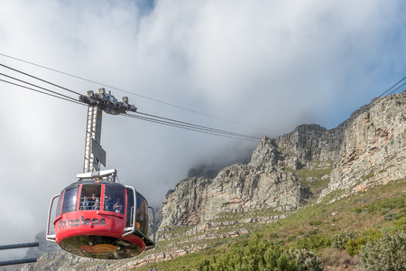 CAPE TOWN, SOUTH AFRICA, AUGUST 17, 2018: Viiew of the Table Mountain Cableway as seen from the lower cable station at Table mountain in Cape Town. A cable car is visible. The cables disappear into the cloudsのeditorial素材