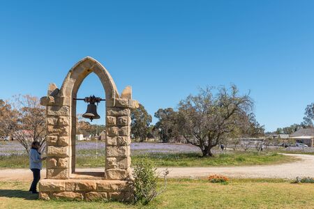 NIEUWOUDTSVILLE, SOUTH AFRICA, AUGUST 29, 2018: Belfry, bell and landscape in front of the Dutch Reformed Church in Nieuwoudtville in the Northern Cape Province. People are visibleのeditorial素材