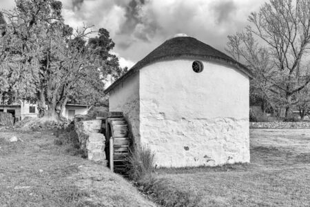KROMRIVIER, SOUTH AFRICA, AUGUST 25, 2018: The historic water mill at Kromrivier Cederberg Park, a holiday resort in the Cederberg Mountains. Monochromeのeditorial素材