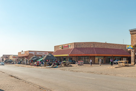 MALELANE, SOUTH AFRICA - MAY 3, 2019: A street scene, with businesses, street vendors and people, in...
