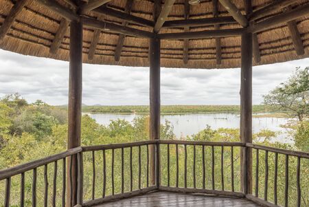 KRUGER NATIONAL PARK, SOUTH AFRICA - MAY 11, 2019: A shaded viewing deck in the Mopani Rest Camp of the Kruger National Park. The Pioneer Dam is visibleのeditorial素材