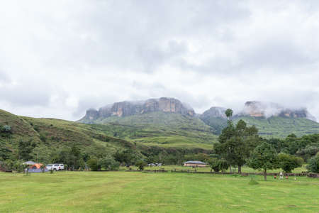 ROYAL NATAL NATIONAL PARK, SOUTH AFRICA - MARCH 16, 2020: A view of the Mahai caravan park and camping site with tents and vehicles. Dooley Hills are visible in the backのeditorial素材