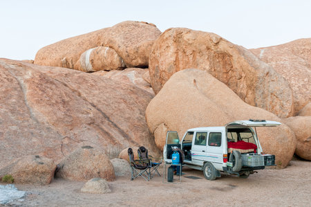 SPITZKOPPE, NAMIBIA - JUNE 18, 2012: Camping at the greater rock arch at Spitzkoppe. A vehicle and camping equipment are visibleのeditorial素材