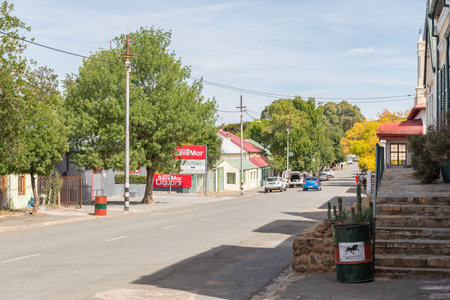 RICHMOND, SOUTH AFRICA - APRIL 2, 2021: A street scene, with old buildings, a business, people and vehicles, in Richmond in the Northern Cape Karoo. Power infrastructure is visibleのeditorial素材