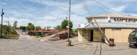 RICHMOND, SOUTH AFRICA - APRIL 2, 2021: A panoramic street scene in Richmond in the Northern Cape Karoo. A supermarket, people and causeway and pedestrian bridge over the Ongers River are visibleのeditorial素材