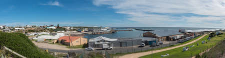 GANSBAAI, SOUTH AFRICA - APRIL 12, 2021: Panoramic view of the harbour in Gansbaai in the Western Cape Province. A caravan park, boats an vehicles are visibleのeditorial素材