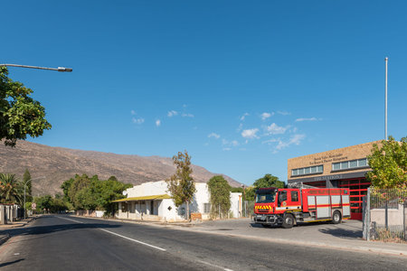 DE DOORNS, SOUTH AFRICA - APRIL 20, 2021: A street scene, with a fire station, fire truck and house,...