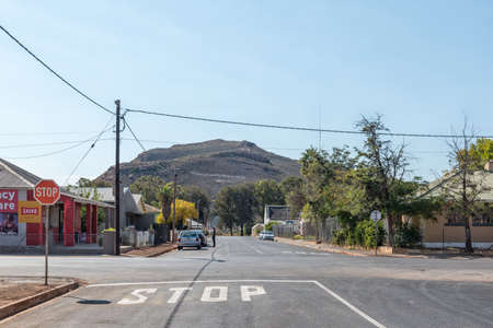 TOUWS RIVER, SOUTH AFRICA - APRIL 20, 2021: A street scene, with buildings, people and vehicles, in Touws River. The name of the town is visible on the Draaiberg Mountain in the backのeditorial素材
