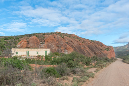 RED STONE HILLS, SOUTH AFRICA - APRIL 6, 2021: A road, farm and mountain landscape at Red Stone...