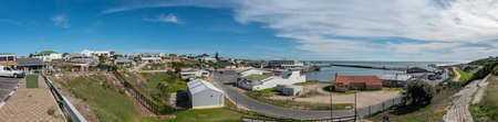 GANSBAAI, SOUTH AFRICA - APRIL 12, 2021: Panoramic view of the harbour in Gansbaai in the Western Cape Province. A caravan park, boats an vehicles are visibleのeditorial素材