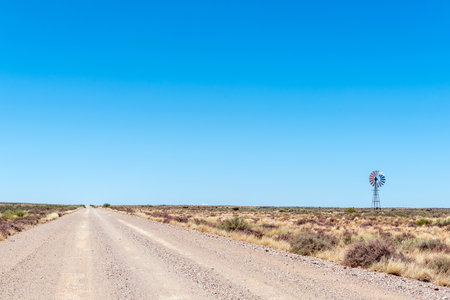 A windmill in a Karoo landscape on road R383 between Kenhardt and Putsonderwater in the Northern Cape Provinceの写真素材