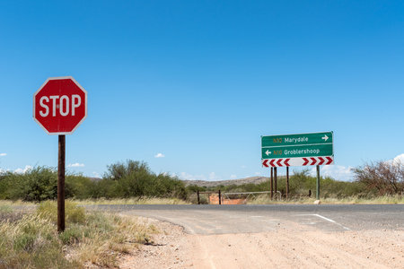 A directional sign and a stop sign at the junction of the Putsonderwater road with road N10の写真素材