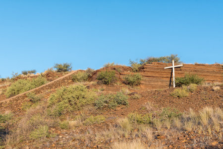 A white religious cross against layers of semi-precious tigers eye stone in The Koppie Nature Reserve in Prieskaの写真素材