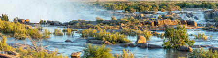 Augrabies National Park, South Africa - Feb 27, 2023: A stitched panorama of the partially flooded boardwalk to the main Augrabies waterfall. The Orange River is in floodの写真素材
