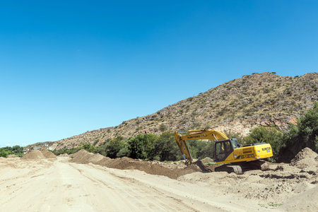 Boegoeberg Dam, South Africa - Feb 28 2023: Backhoe loaders clearing sand that blocked the irrigation canal near the Boegoeberg Damのeditorial素材