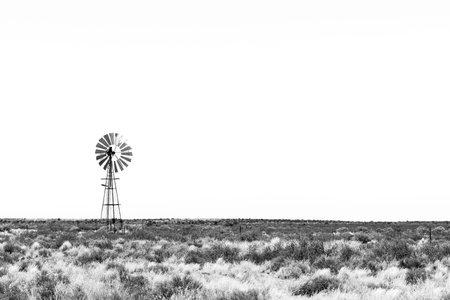 A windmill in a Karoo landscape between Kenhardt and Putsonderwater in the Northern Cape Province. Monochromeの写真素材