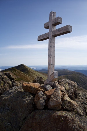 mountain cross with bit mountains in the background