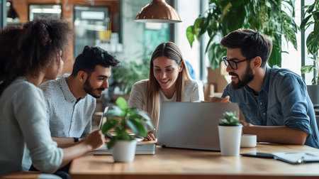 Group of professionals working together in an office, collaborating around a laptop during a team meeting. Great for teamwork, startup, and corporate use.の写真素材
