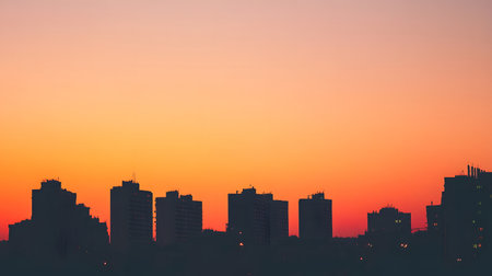 Silhouetted buildings under a warm sunset sky. Great for architectural mood boards, background for text, or elegant scenes.の写真素材