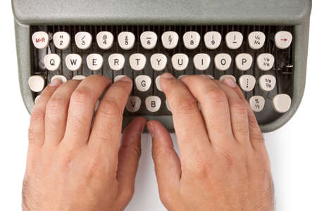 Hands on a typewriter keyboard on a white backgroundの写真素材