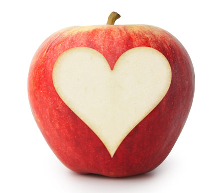 Heart cut out of the side of an apple in white backgroundの写真素材