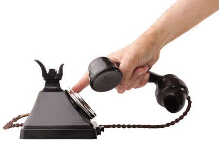 Hand holding the receiver and dialing an old bakelite telephone. GPO 200 Series. 232 model. Isolated on white with clipping pathの写真素材
