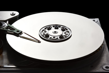 Open hard disk drive showing the read write arm and platter