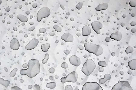 Drops of water on a grey metal tableの写真素材