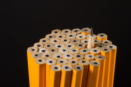 A sharpened pencil among a set of unsharpened pencils