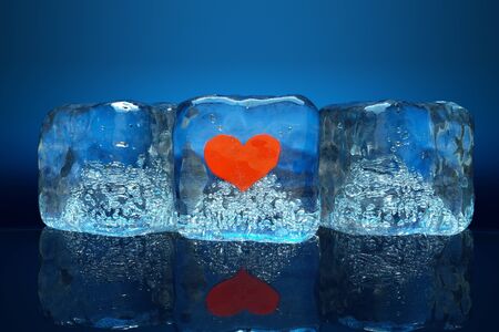 a frozen red heart as a simbol of frozen love, ice cubes with heartの写真素材