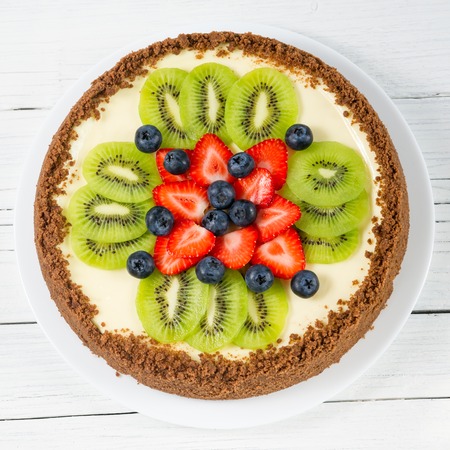Cheesecake with kiwi, blueberry and strawberry on a plateの写真素材