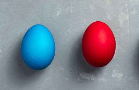 Blue and red Easter eggs on textured gray background. Horizontal orientation. Top view.の写真素材