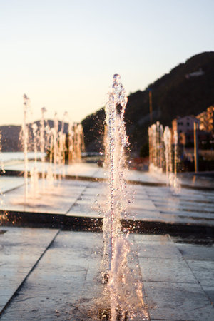 The jet of the fountain of water in which the refracted ray of sunshineの写真素材