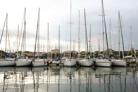 Sailboats in a row next to the pier on the seaの写真素材