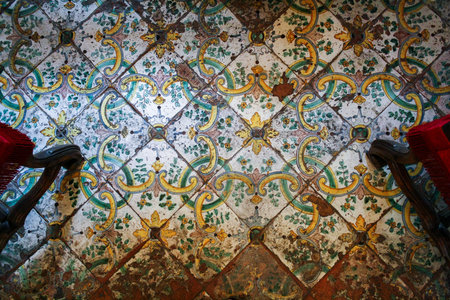 Old shabby tiled floor with a beautiful yellow-green ornament on a white fieldの写真素材
