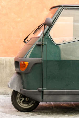 Dusty green cabin cargo scooter in front of orange wallの写真素材