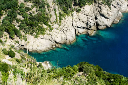 Rocky shore and clear blue sea in the hot summer.の写真素材
