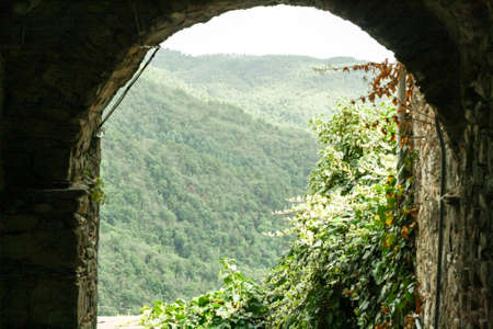 View through the ancient archway in the wooded mountains.の写真素材